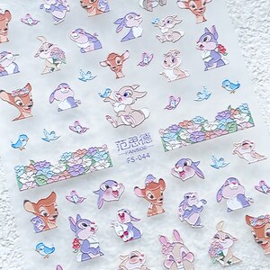 Peut inclure: Une feuille de papier autocollant transparent avec une vari&eacute;t&eacute; d'autocollants de dessins anim&eacute;s color&eacute;s repr&eacute;sentant Bambi et Panpan. Les autocollants sont dispos&eacute;s en rang&eacute;es et comprennent des images des personnages avec des fleurs, des oiseaux et des papillons. Le texte "花边贴 - FANSIDE - FS-044" est imprim&eacute; sur la feuille.