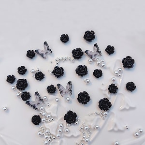 Puede incluir: Adornos de mariposa y rosa en blanco y negro. Estos pequeños amuletos decorativos son perfectos para agregar un toque de elegancia a las manualidades, las joyas y otros proyectos.