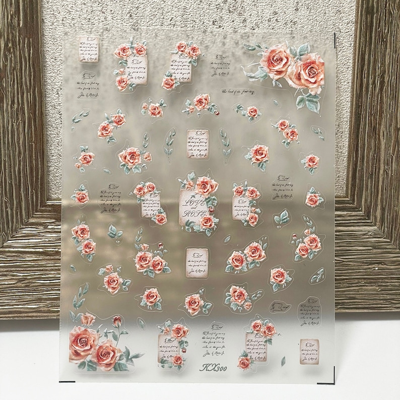 Puede incluir: Hoja transparente de pegatinas florales con rosas de acuarela melocot&oacute;n y rosas y hojas verdes. Las pegatinas incluyen escritura a mano y la palabra "LOVE".