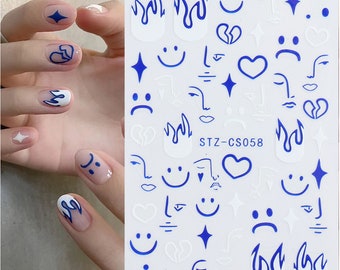 May include: A sheet of nail art stickers featuring blue graphic designs including flames, smiley faces, sad faces, hearts, abstract faces, and stars. The sheet is labeled with the text STZ-CS058 and displays various icons in a repeating pattern.