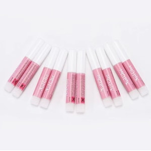 May include: A collection of nail glue tubes with white caps and pink labels. The labels read "Nail Glue" in a cursive font. The tubes are arranged in a fan shape against a white background. The word "CAUTION" and an "X" symbol are also visible.