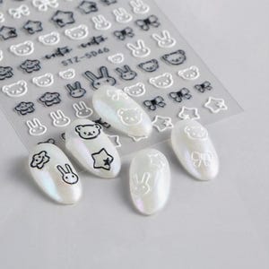 Adesivos de unha fofos de desenho animado branco e preto, design de estrela de arco de coelho de urso 3D, decalques de arte de unha kawaii adoráveis para unhas faça você mesmo