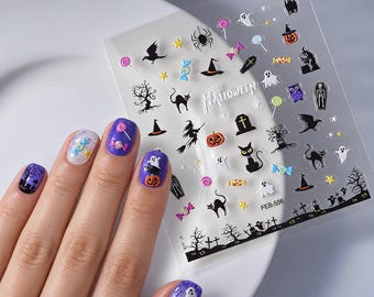 May include: A sheet of Halloween-themed nail art stickers featuring ghosts, pumpkins, black cats, witches, and candy designs. The clear adhesive sheet includes the text HALLOWEEN and FEB-556, displayed alongside fingernails painted in purple and white.