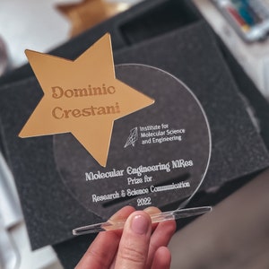 Trofeo grabado personalizado con estrella de acrílico espejado. Premio personalizado para egresados 2025.