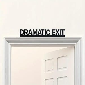 May include: A black sign that reads "DRAMATIC EXIT" is mounted above a white door frame. The door is slightly ajar, revealing the interior. The sign is in a bold, sans-serif font.