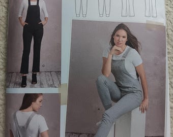 May include: Simplicity sewing pattern S8855 for knit overalls. The pattern includes multiple views of the overalls, with a variety of styles. The image shows the overalls in gray and black, with the text "THE KNIT OVERALL".