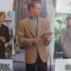May include: Vogue Men's sewing pattern featuring three men's jacket styles. The pattern includes a double-breasted navy blazer, a tan blazer with a gray turtleneck, and a gray blazer with a burgundy scarf. The pattern size is 38-40-42.