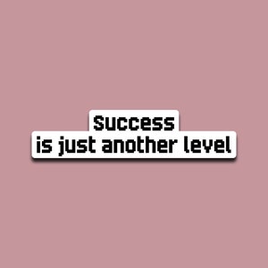 May include: White sticker with black text that reads "Success is just another level".