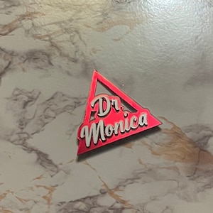 K&ouml;nnte beinhalten: Ein rotes dreieckiges Schild mit wei&szlig;er Aufschrift "Dr. Monica"