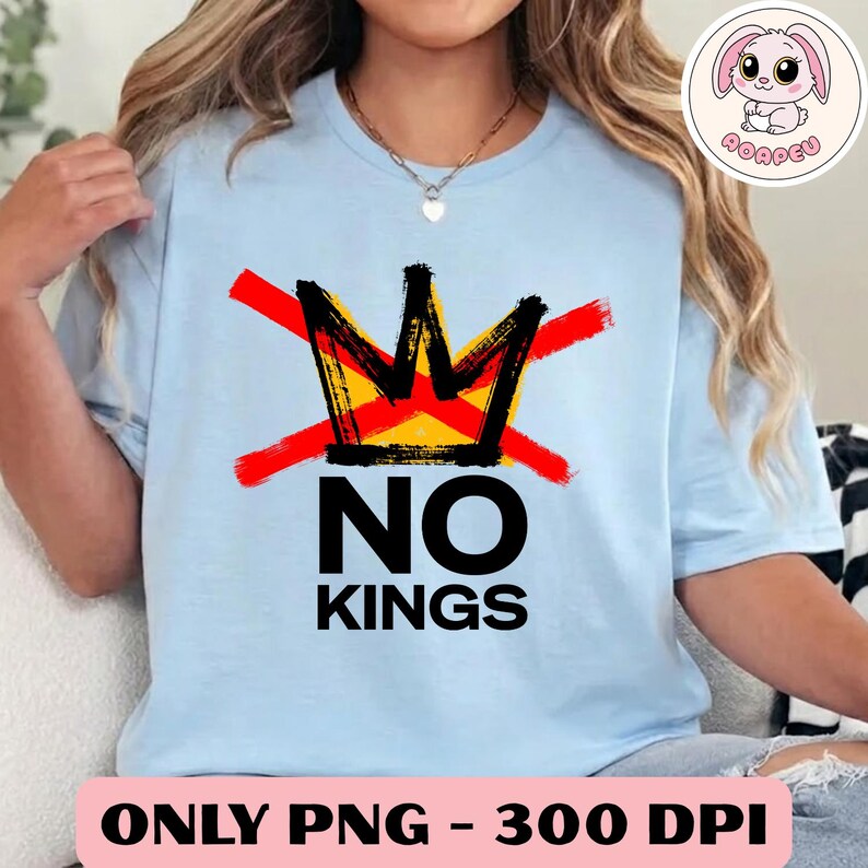 May include: Light blue t-shirt with a graphic design featuring a yellow and black crown crossed out with red lines, and the words "NO KINGS" in black. The shirt also has the text "ONLY PNG - 300 DPI".