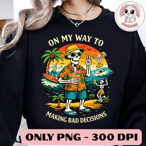 May include: Black sweatshirt featuring a vibrant graphic of a skeleton in holiday attire, wearing sunglasses and a Hawaiian shirt, holding a cocktail and giving a peace sign. Text reads "ON MY WAY TO MAKING BAD DECISIONS".