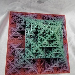 May include: A colorful geometric pattern in shades of red, green, and blue. The pattern is made up of a series of triangles that are arranged in a repeating pattern. The pattern is reminiscent of a fractal.