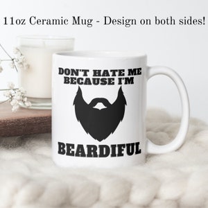 May include: White ceramic mug with a black beard design and the text "Don't hate me because I'm Beardiful".
