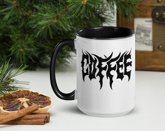 May include: White ceramic coffee mug with a black rim and handle. The mug features a black graphic of the word "COFFEE" in a stylized, gothic font.