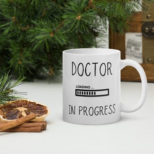 May include: White ceramic mug with black text that reads "DOCTOR LOADING... IN PROGRESS" with a progress bar graphic.