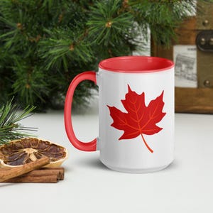 Peut inclure: Une tasse à café en céramique blanche avec un intérieur rouge et un motif de feuille d'érable rouge. La tasse a une capacité de 440 ml.