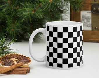 May include: White ceramic mug with a black and white checkered pattern.