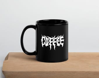May include: Black ceramic coffee mug with a white stylized "COFFEE" design.