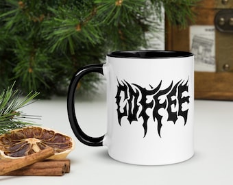 May include: White ceramic coffee mug with a black rim and handle. The mug has a black graphic of the word "COFFEE" in a stylized, gothic font.