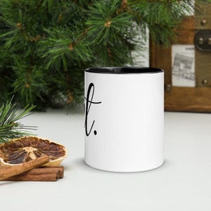 May include: White ceramic mug with a black rim and handle. The mug has black text that says "Just."
