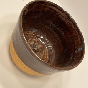 May include: A set of three ceramic mugs with a speckled, matte finish. The mugs are in shades of cream, light gray, and dark gray. Each mug has a simple, minimalist design and a rounded handle. Perfect for coffee or tea.