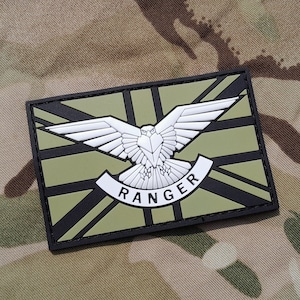 May include: A green and black patch with a white falcon and the word "RANGER" in a white banner. The patch has a Union Jack design.