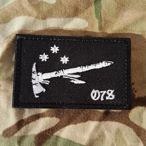 May include: Black embroidered patch with a white axe and four stars. The text "078" is embroidered in white below the axe.