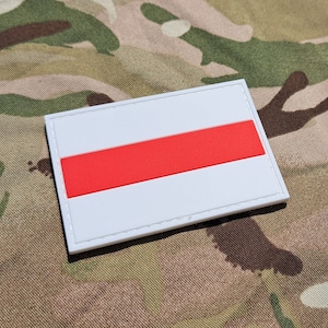 Può includere: Toppa bianca con una striscia orizzontale rossa, che ricorda una bandiera.