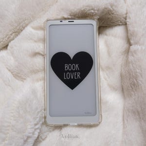 Op de afbeelding: Een witte e-reader met een zwart hart waarop "BOOK LOVER" staat. De e-reader zit in een transparante hoes.