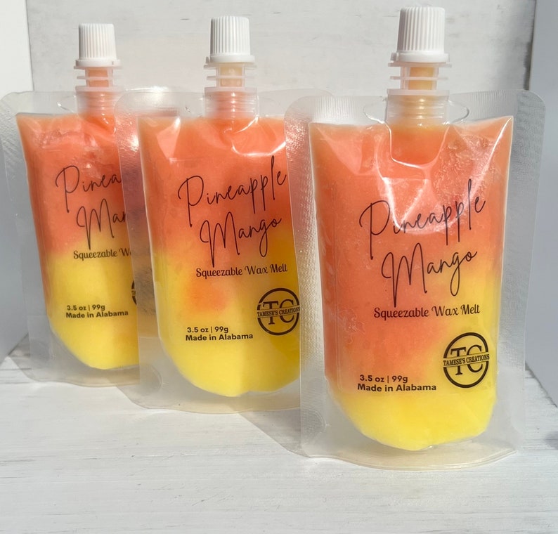 May include: Three pouches of pineapple mango scented wax melts. Each pouch is clear and shows the wax melt inside. The wax melt is a gradient of yellow and orange. The pouches have a label that says "Pineapple Mango" and "Squeezable Wax Melt". The label also says "3.5 oz | 99g Made in Alabama".