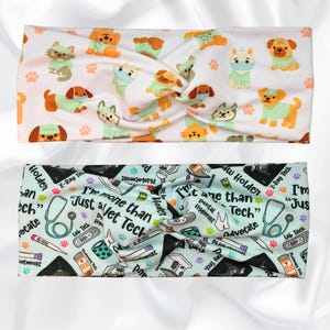 May include: Two headbands. The top one is white with a pattern of cartoon dogs and cats in various colors. The bottom headband is light blue with veterinary-themed illustrations and the text "I'm more than just a Vet Tech."