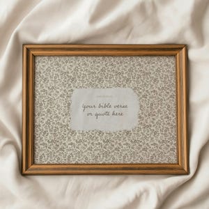 Può includere: Una cornice rettangolare in legno con sfondo floreale e inserto di carta strappata. L'inserto recita "your bible verse or quote here" in un carattere scritto a mano. La cornice ha una finitura marrone caldo.