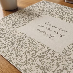May include: A floral patterned notebook with the text "His mercies are new every morning" in a central square. The notebook has a beige background with a repeating pattern of small, gray flowers.