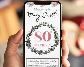 Può includere: Un invito digitale per una festa di compleanno di 80 anni. L'invito presenta una ghirlanda di fiori con il numero 80 al centro. Il testo recita "Si prega di unirsi a noi per l'80° compleanno di Mary Smith. Sabato 1 giugno, 15:00 - 18:00 - La casa degli Smith - 2234 Lurrel Street, San Diego, CA 92101. Si prega di RSVP a Jane tramite SMS al 239.339.3378."