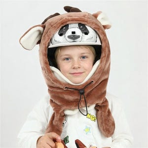 May include: A brown plush animal-themed helmet cover featuring large ears and antlers, designed to fit over a white helmet with a black and white panda face graphic on the front. The cover includes a black drawstring toggle for a secure fit.