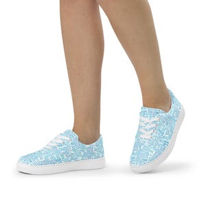 May include: A pair of low-top sneakers featuring a light blue and white circuit board pattern across the fabric upper. The shoes have white laces, white eyelets, and a solid white rubber sole, providing a clean look for casual footwear.