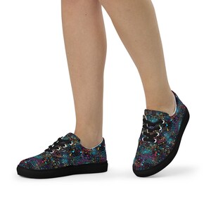 May include: Low-top sneakers featuring a dark background with a vibrant, multicolored abstract circuit board pattern. The shoes have black laces, black eyelets, and a solid black rubber sole, creating a high-contrast look with neon-like accents.