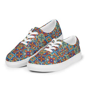 May include: A pair of canvas sneakers with a colorful mosaic pattern in shades of blue, orange, and yellow. The shoes have white laces and soles.