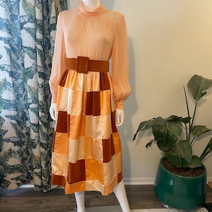 Puede incluir: Una taza de cerámica blanca con asa negra y el texto "But First, Coffee" en negrita negra. La taza se encuentra sobre un fondo borroso, sugiriendo un ambiente acogedor.