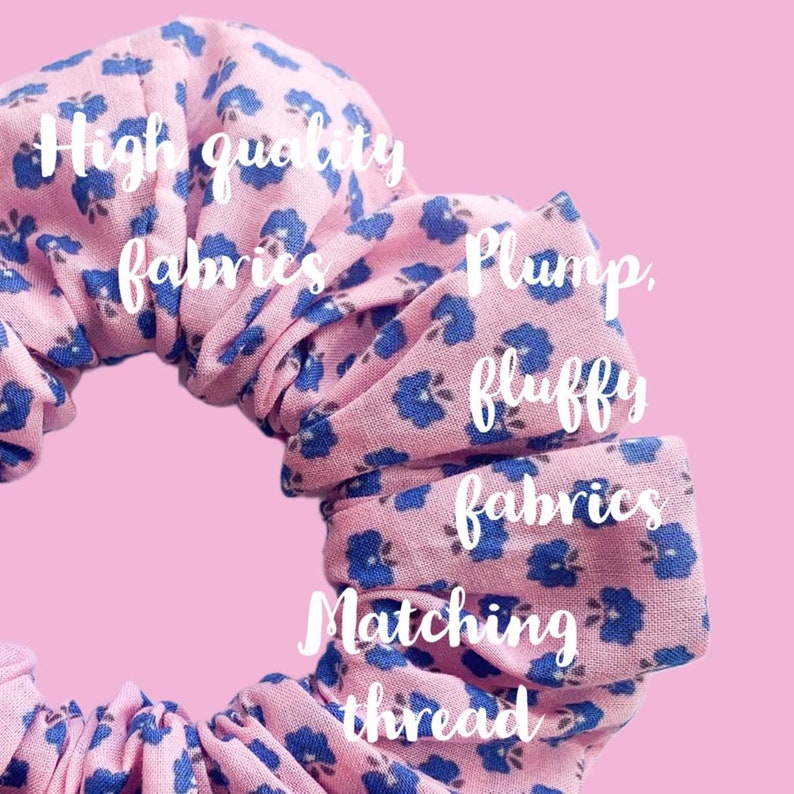 May include: A pink and blue floral scrunchie made with high quality, plump, and fluffy fabrics. The scrunchie is made with matching thread.