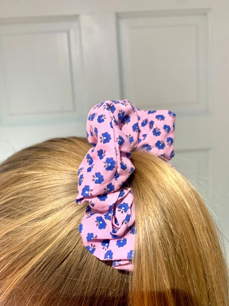 May include: A pink and blue floral patterned scrunchie for hair.