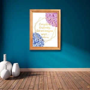 Puede incluir: Una impresión enmarcada con un diseño geométrico dorado y una cita que dice "Todo tiene belleza, pero no todos la ven..." La impresión presenta una ilustración de acuarela de hortensias rosas y azules.