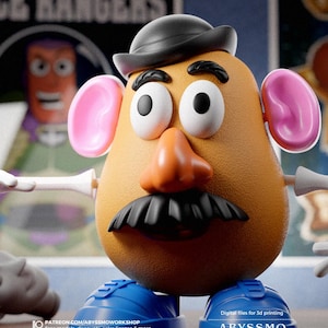 May include: A 3D-printed Mr. Potato Head toy with a black hat, mustache, and blue shoes. The toy has pink ears, a large orange nose, and white eyes. The background includes text that reads "SPACE RANGERS" and "ABYSSMO WORKSHOP".