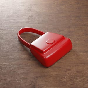 Pode incluir: Uma mala de mão vermelha brilhante com uma alça arredondada e um pequeno fecho circular. A mala tem uma forma retangular com um topo ligeiramente curvo. Está sobre uma superfície de madeira.
