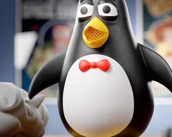 Puede incluir: Una figura de pingüino con cuerpo negro, vientre blanco, pico amarillo y pajarita roja. La figura tiene grandes ojos blancos con pupilas negras. El texto en la parte inferior dice: Digital files for 3d printing ABYSSMO WORKSHOP.
