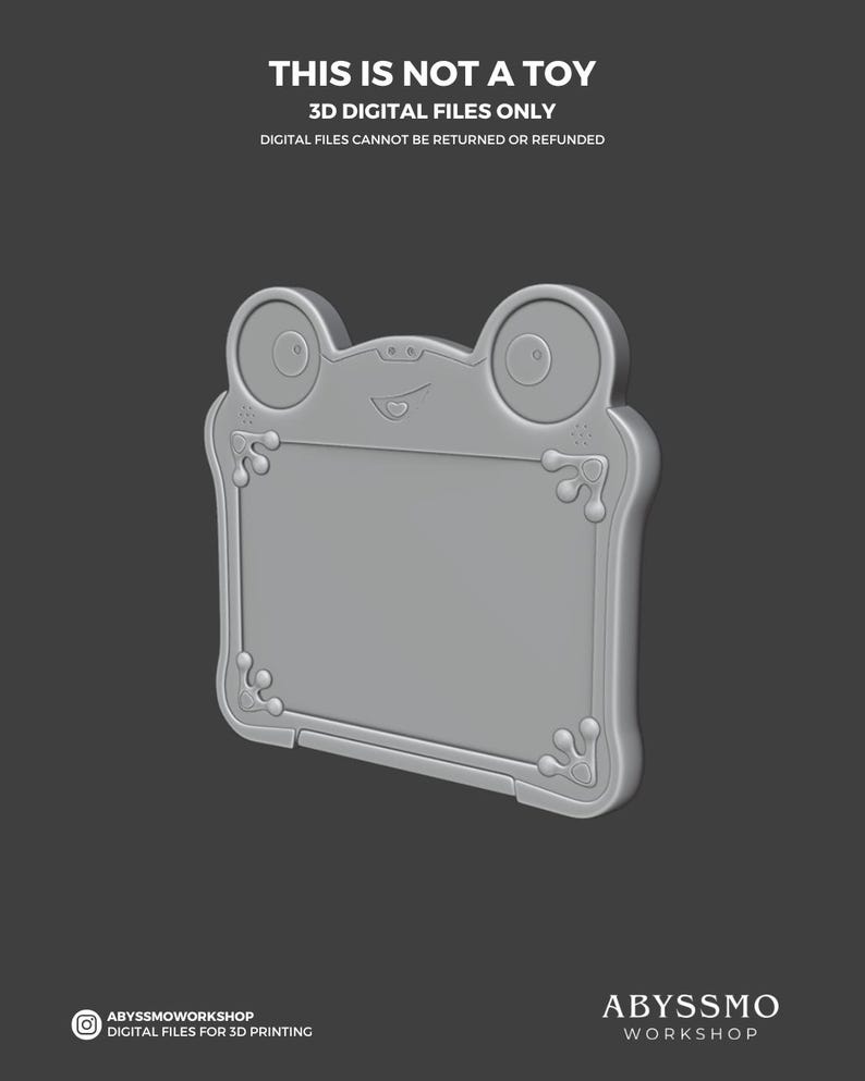 Puede incluir: Una tableta de dibujo digital gris con forma de rana. La tableta tiene una pantalla rectangular con esquinas redondeadas y elementos decorativos. El texto "THIS IS NOT A TOY" y "3D DIGITAL FILES ONLY" es visible. El logotipo de Abyssmo Workshop est&aacute; en la parte inferior.