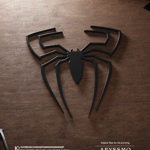 Puede incluir: Modelo impreso en 3D negro de un diseño de telaraña. El diseño está sobre una superficie de madera. El texto "Archivos digitales para impresión 3D" y "ABYSSMO WORKSHOP" está en la parte inferior de la imagen.