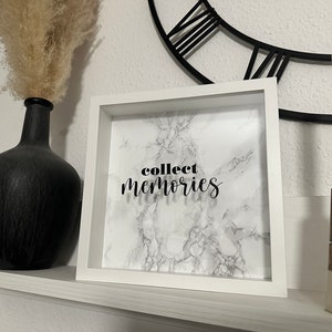 Könnte beinhalten: Weißer Bilderrahmen mit Marmorhintergrund und dem Text "collect memories" in schwarzen Buchstaben.