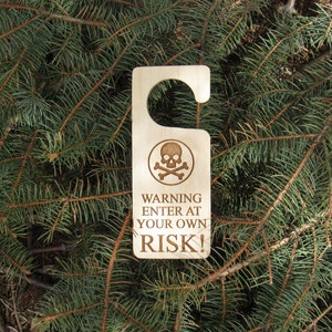 May include: Wooden door hanger with a skull and crossbones graphic and the text "WARNING ENTER AT YOUR OWN RISK!"
