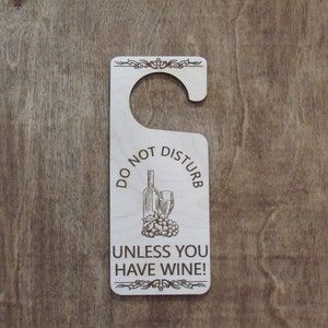 May include: Wooden door hanger with the text "Do Not Disturb Unless You Have Wine!" and a drawing of a bottle of wine and a wine glass.